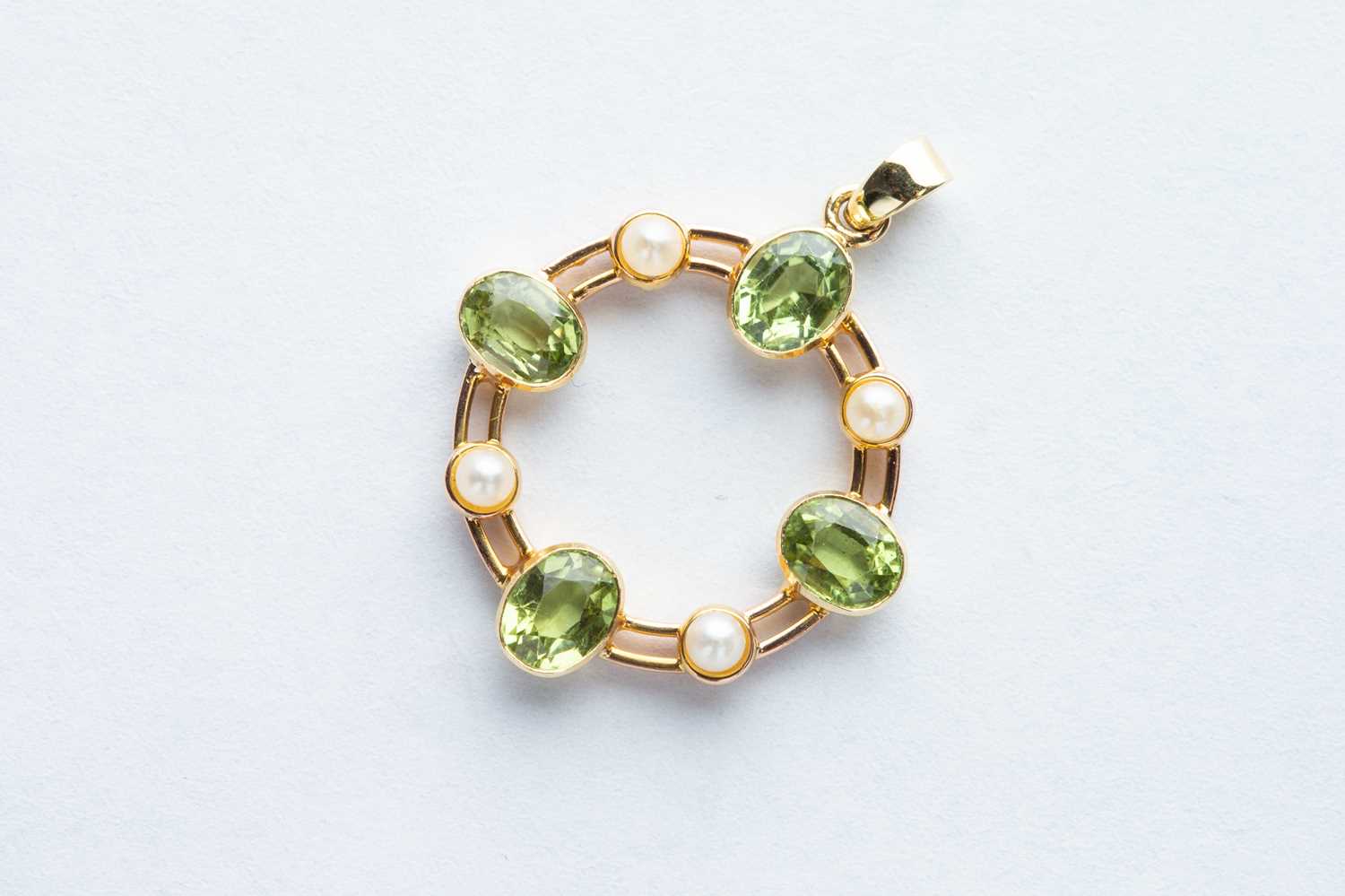 Lot 14 - A 18ct Yellow Gold Peridot & Cultured Seed Pearl Circle Pendant