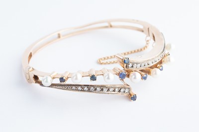 Lot 65 - A 14ct  Gold Continental Sapphire, Diamond & Seed Pearl Crossover Bangle Bracelet