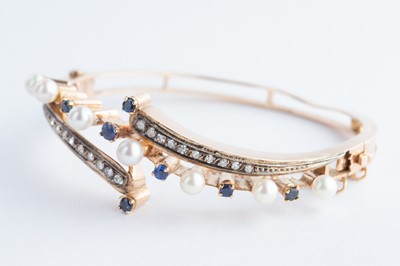 Lot 65 - A 14ct  Gold Continental Sapphire, Diamond & Seed Pearl Crossover Bangle Bracelet