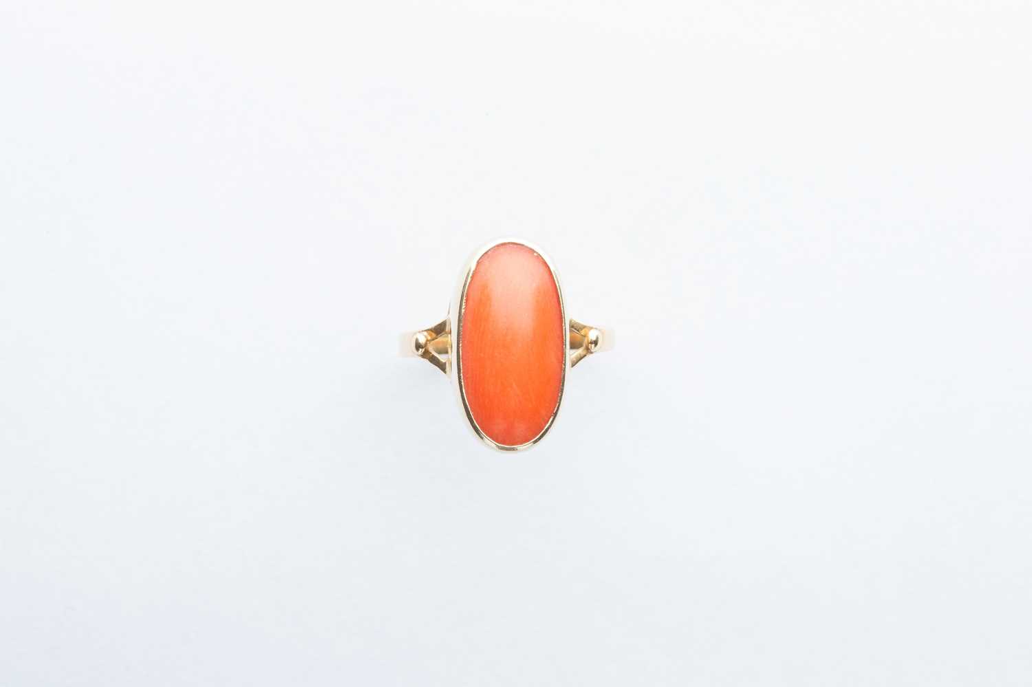 Lot 82 - A Yellow Metal Oval Orange Coral Ring